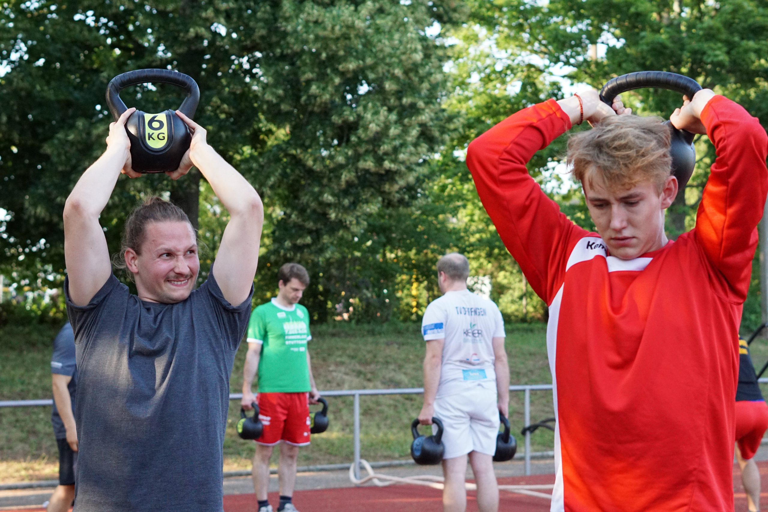 Gruppe Handballer bei einer Übung mit Kettlebells Gruppe Handballer bei einer Übung mit Kettlebells