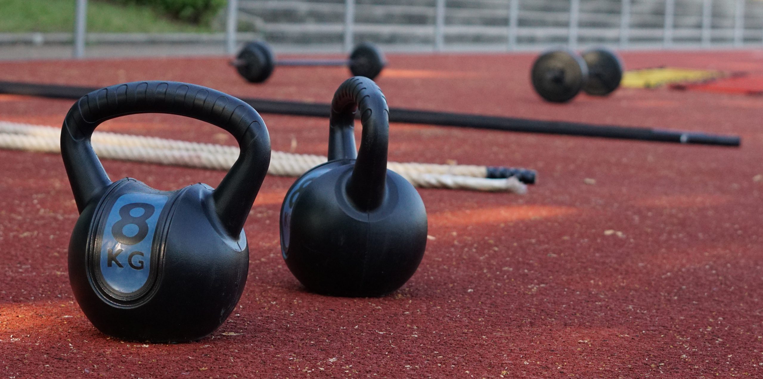 Kettlebells und Battle ropes auf der Tartanbahn